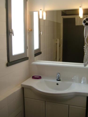 a bathroom with a sink and a mirror at Le Parasol in Ars-en-Ré