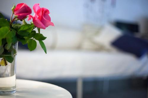a glass vase with pink roses sitting on a table at Relais Del Lago in Capannori