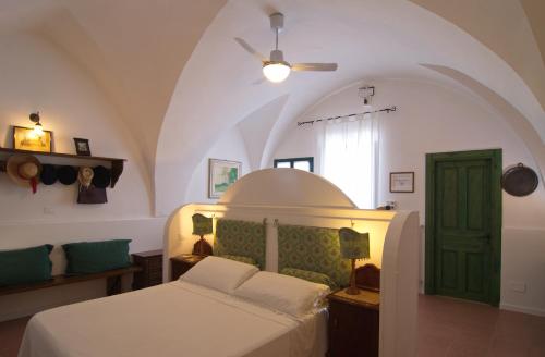 a bedroom with a bed and a green door at Masseria Il Frantoio in Ostuni