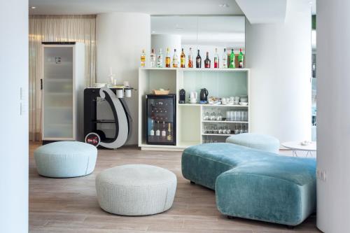 a living room with two ottomans and two stools at Tigotan Lovers & Friends Playa de las Americas - Adults Only (+18) in Playa de las Americas