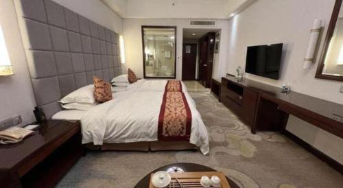 a hotel room with a bed and a television at Putian Haiyuan International Hotel in Putian