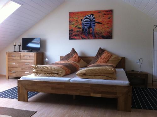 ein Sofa im Wohnzimmer mit einem Zebra-Gemälde an der Wand in der Unterkunft Appartement Kirchenblick in Bad Birnbach