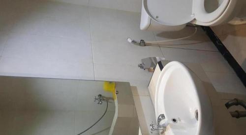 a bathroom with a white sink and a toilet at Kharisma Hotel in Madiun
