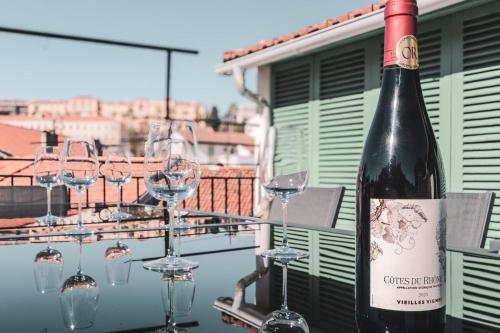- une bouteille de vin assise sur une table avec des verres à vin dans l'établissement Lux PH Gem 3BR 200m palais and beach, à Cannes