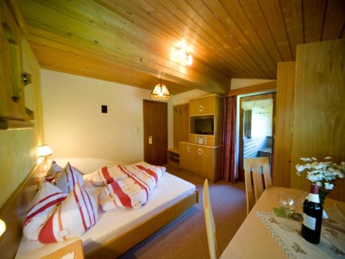 a bedroom with a bed and a table in a room at Gästehaus Bergland in Berwang