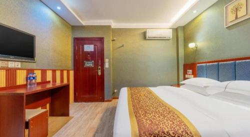 a bedroom with a bed and a desk and a tv at Super 8 Hotel Shiyan Beijing Middle Road in Shiyan