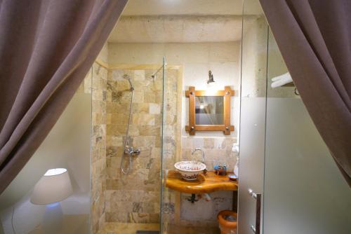a bathroom with a shower with a sink and a mirror at Kemerli House in Avanos