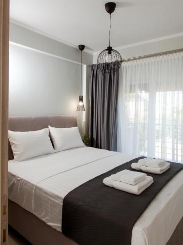 a bedroom with a large bed with two towels on it at Ammoshine Suite 1 in Nea Peramos