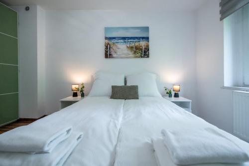 a bedroom with a large white bed with two lamps at Apartament Lipowa 26 in Gliwice
