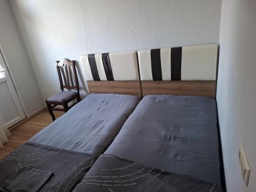a bed sitting in a room with a chair at Guesthouse Toma in Gonio