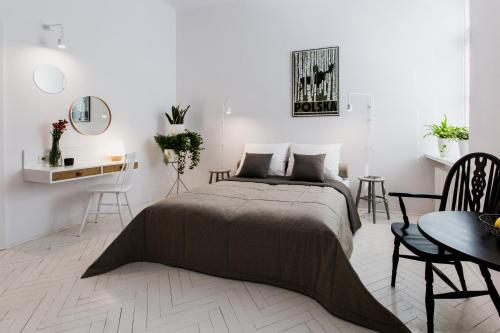 a bedroom with a bed and a table and chairs at Apartamenty Browar Perła - free Parking in Lublin