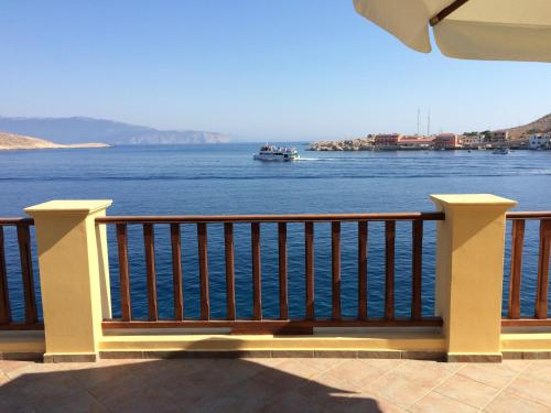 a bench on a balcony looking out over the water at Villa Amalia in Halki
