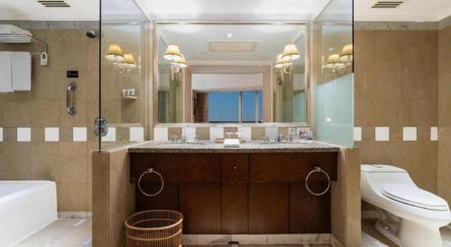 a bathroom with a toilet and a sink and a mirror at Kai Wah Plaza International Hotel in Kunming