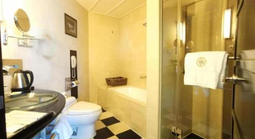 a bathroom with a shower and a toilet and a sink at Changsha Huatian Hotel in Changsha