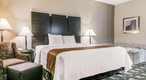 a hotel room with a large bed and a chair at Suburban Studios Mason Hwy 42 in Mason