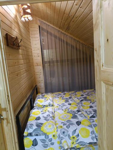 a bedroom with a bed in a wooden room at Diamond in Cholpon-Ata