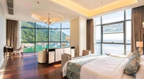 a bedroom with a large bed and large windows at The Century Seaview Hotel in Shenzhen