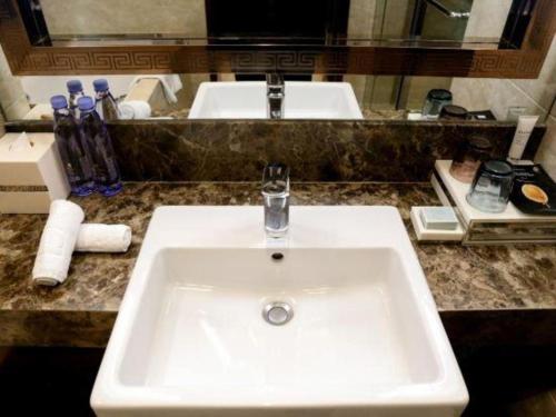 a white sink in a bathroom with a mirror at Xi'an Airport Hotel in Xi'an