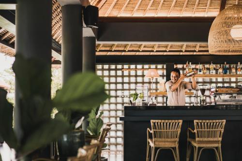 a bartender behind the bar at a restaurant at The Retreat at Kharista by Ekosistem in Canggu
