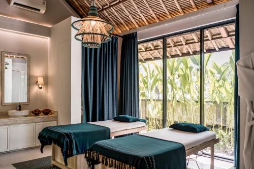 two beds in a room with a window at The Retreat at Kharista by Ekosistem in Canggu