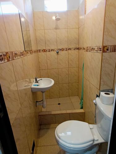 a small bathroom with a toilet and a sink at Hospedaje Live in Tingo María