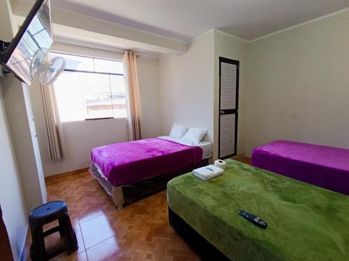 a room with two beds and a tv in it at Hospedaje Live in Tingo María