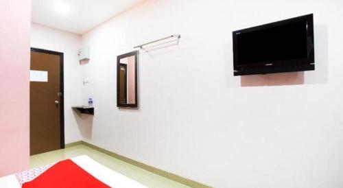 a room with a flat screen tv on a wall at OYO 89539 Hotel Siswa in Kampar