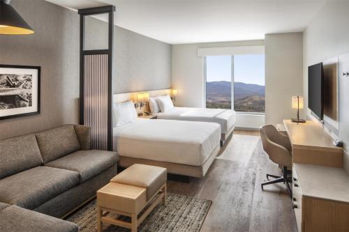 a hotel room with two beds and a couch at Hyatt Place Reno in Reno