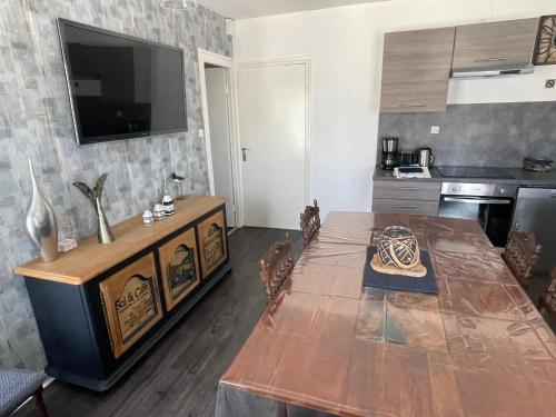 Il comprend une cuisine avec une table et une télévision murale. dans l'établissement La légende Pontsuval 2eme étage - Centre-ville Brignogan-Plages , 300 m des plages, à Brignogan-Plage