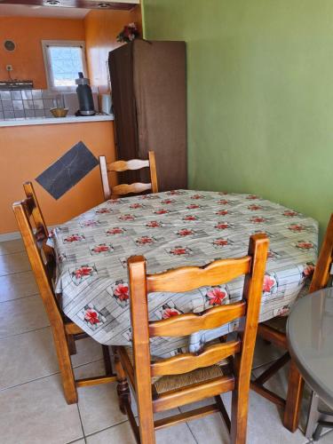 - une table à manger avec des chaises, une table et une table dans l'établissement La mouette Clim vue mer accès plage direct, à Fleury