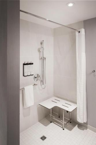 a white bathroom with a shower and a table at Hyatt Place Reno in Reno