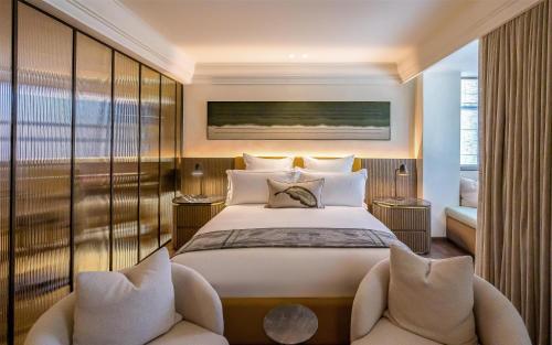 a bedroom with a large bed and two chairs at Park Hyatt Johannesburg in Johannesburg