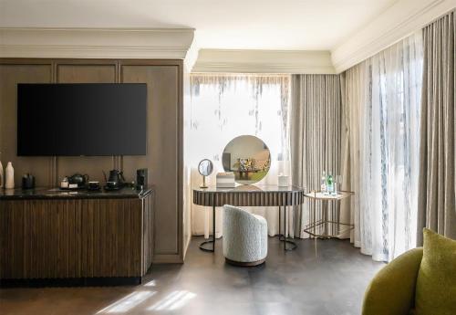a living room with a television and a table and a chair at Park Hyatt Johannesburg in Johannesburg