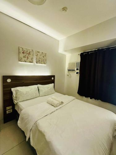 una camera da letto con due letti con lenzuola bianche di 36T2 Chic Corner, Horizons 101, Cebu City a Cebu City