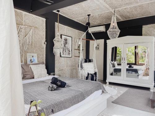 Un dormitorio con una cama blanca y un espejo. en Indi Pixy Haven, en Gili Air
