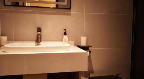 a bathroom sink with a soap dispenser on it at GreenTree Inn Datong YundinGYAyuan Express Hotel in Datong