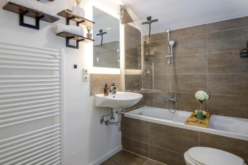 a bathroom with a sink and a toilet and a tub at 3 BR - Familienfreundlich - Geräumig - Zentral - Wifi - Cozy in Wiesbaden