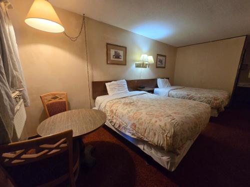 a hotel room with two beds and a table at OYO Sandman Inn in Eagle Grove