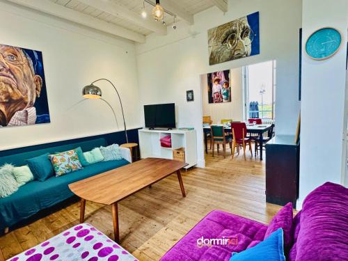 un salon avec un canapé et une table dans l'établissement Maison GALERIE - Port de Mornac & Art de vivre, à Mornac-sur-Seudre
