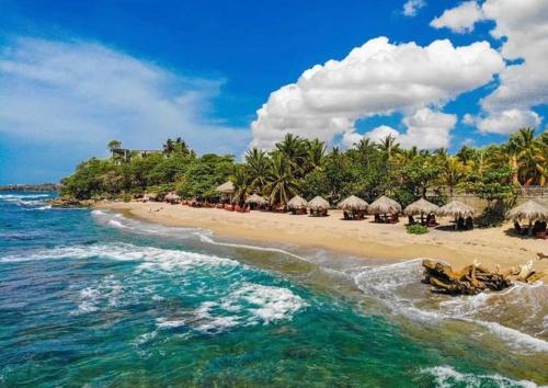 an einem leeren Strand mit Sonnenschirmen und dem Meer in der Unterkunft Ichi paradise najayo beach in San Cristóbal
