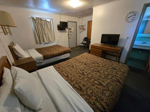 a hotel room with two beds and a television at OYO Sandman Inn in Eagle Grove