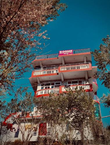 a tall building with trees in front of it at Nature View Home Stay in Mandi