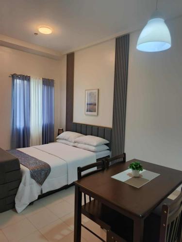 a bedroom with a bed and a table and a tableablish at Hills Staycation by SDC in Manila