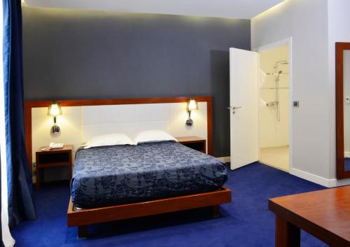 Кровать или кровати в номере Hôtel Ambassadeur