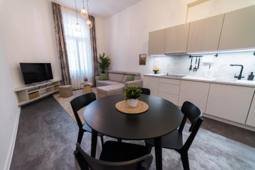 a kitchen and living room with a table and chairs at Feketesas Apartman in Szeged