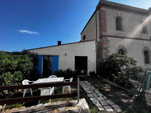 a building with two white chairs in front of it at Eroico sul Mare in Portoferraio