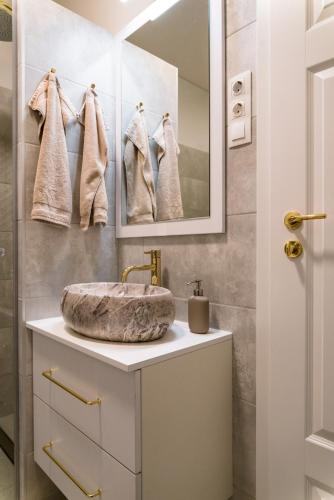 a bathroom with a sink and a mirror at Feketesas Apartman in Szeged