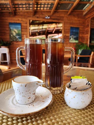 a table with two mugs of tea and two cups at The Chalets Naldehra in Shimla