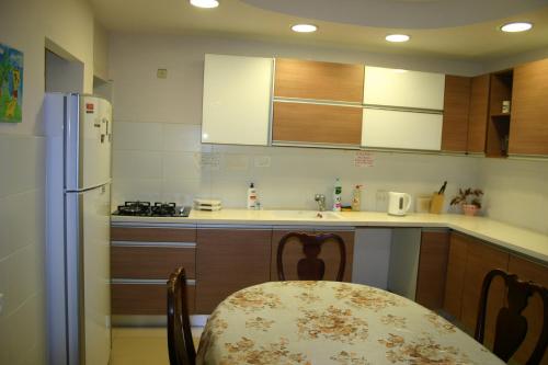 cocina con mesa y cocina con nevera en Ocean View Luxury apartment, en Netanya
