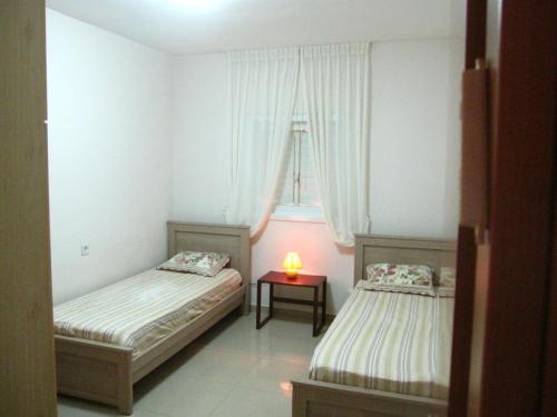 two beds in a room with a lamp on a table at Ocean View Luxury apartment in Netanya